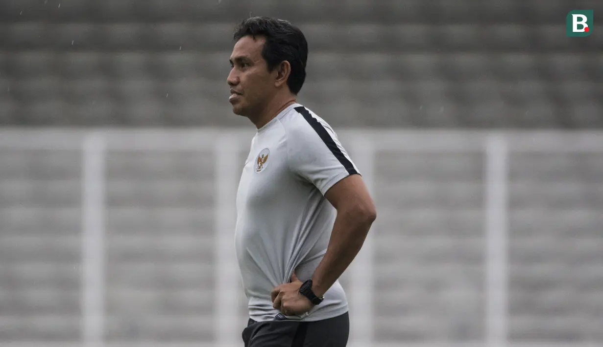 Pelatih Timnas Indonesia, Bima Sakti, mengamati anak asuhnya saat latihan di Stadion Madya, Jakarta, Minggu (11/11). Latihan ini persiapan jelang laga Piala AFF 2018 melawan Timor Leste. (Bola.com/Vitalis Yogi Trisna)