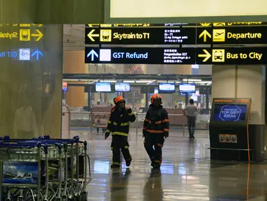 Petugas berada di bandara internasional Changi usai terjadi kebakaran kecil di salah satu terminal, Singapura, Selasa (16/5). Polisi mengatakan, alarm kebakaran terdengar pada pukul 17.40 saat asap muncul dari lubang-lubang ventilasi. (AFP/ TOH TING WEI)