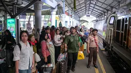 Jumlah tersebut terdiri dari 26.555 penumpang keberangkatan dan 20.670 kedatangan. Tampak dalam foto, para penumpang menunggu untuk naik kereta di stasiun Gubeng, Surabaya, Jawa Timur, Selasa 17 Maret 2026. (JUNI KRISWANTO/AFP)