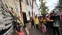 Pengunjung berfoto dengan wanita yang mengenakan kostum di kawasan wisata Kota Tua, Jakarta, Selasa (27/6). Memasuki libur lebaran hari ke-3, kawasan wisata Kota Tua penuh dikunjungi warga. (Liputan6.com/Yoppy Renato)