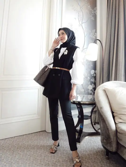 <p>Gaya Melody Prima satu ini bisa jadi inspirasi gaya formal yang simpel namun tetap modis dengan celana jeans hitam. Padukan blouse putih, vest, dan celana jeans hitam. Tambahkan aksesori berupa belt dan bros supaya look-mu makin modis! (Instagram/melodyprima).</p>
