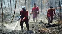 Personel BBKSDA Riau memadamkan kebakaran lahan di Suaka Margasatwa Giam Siak Kecil. (Liputan6.com/Dok BBKSDA Riau)
