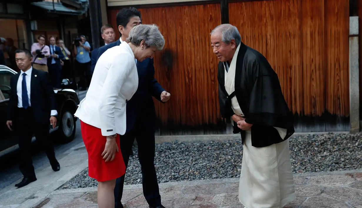 Perdana Menteri Inggris Theresa May (kiri) didampingi Perdana Menteri Jepang Shinzo Abe (tengah) memberi salam kepada Master of Tea Ceremony Sen Sosa di Kyoto, Jepang (30/8). (Kim Kyung-hoon/Pool Photo via AP)