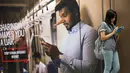 Penumpang menunggu kedatangan kereta di sebelah iklan tentang larangan penyebaran hoax atau berita bohong di Stasiun Kereta Kuala Lumpur, Malaysia, Kamis (29/3). Pemerintah Malaysia mengesahkan undang-undang (UU) Antihoax. (AP Photo/Vincent Thian)