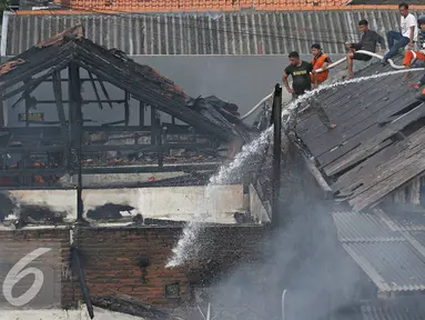Petugas bersama warga berusaha memadamkan api yang membakar pemukiman penduduk di Jalan Gelora IX A, Palmerah, Jakarta, Kamis (4/8). Api yang diduga berasal dari arus pendek itu membakar 8 rumah. (Liputan6.com/Immanuel Antonius)