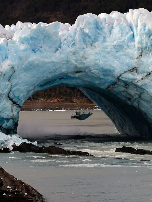 Bongkahan es runtuh dari Perito Moreno Glacier di Taman Nasional Los Glaciares, Argentina, Kamis (10/3). Tekanan yang sangat besar yang dihasilkan ketinggian air yang terbendung akhirnya memecah penghalang es dengan spektakuler. (AFP PHOTO/Walter Diaz)