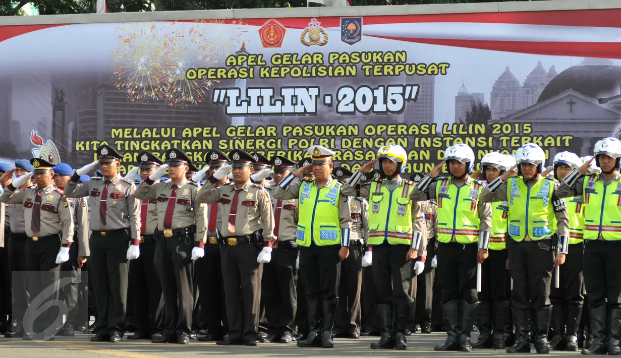 Polisi memberi penghormatan saat apel kesiagaan pasukan Operasi Lilin 2015 di halaman Mapolda Metro Jaya, Jakarta, Rabu (23/12). Apel gelar pasukan pengamanan Natal & tahun baru ini dipimpin oleh Kapolri Jenderal Badrodin Haiti.(Liputan6.com/Yoppy Renato)