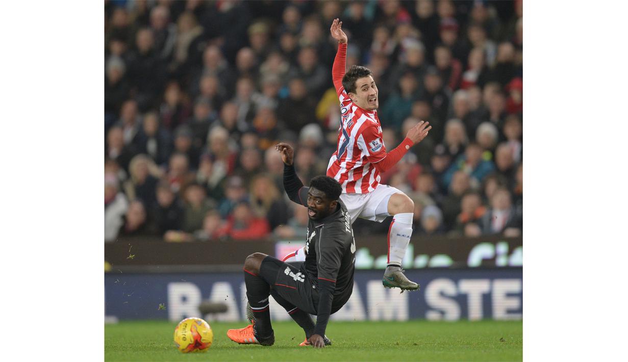 Pemain Liverpool, Kolo Toure (kiri)  menghalau bola dari kejaran pemain Stoke City, Bojan Krkic pada Leg pertama semi-final Piala Liga Inggris di Stadion Britannia; Stoke-on-Trent; Inggris; Rabu (06/01/2016) dini hari WIB. (AFP Photo/Oli Scarff)