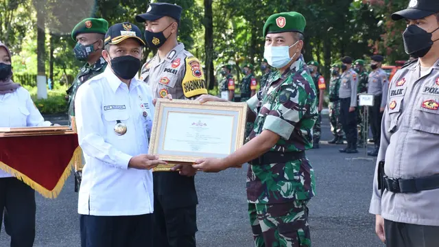 Bupati Wonosbo menyerahkan piagam penghargaan kepada tim Satgas Covid 19. (Foto: Pemkab Wonosobo/Liputan6.com)