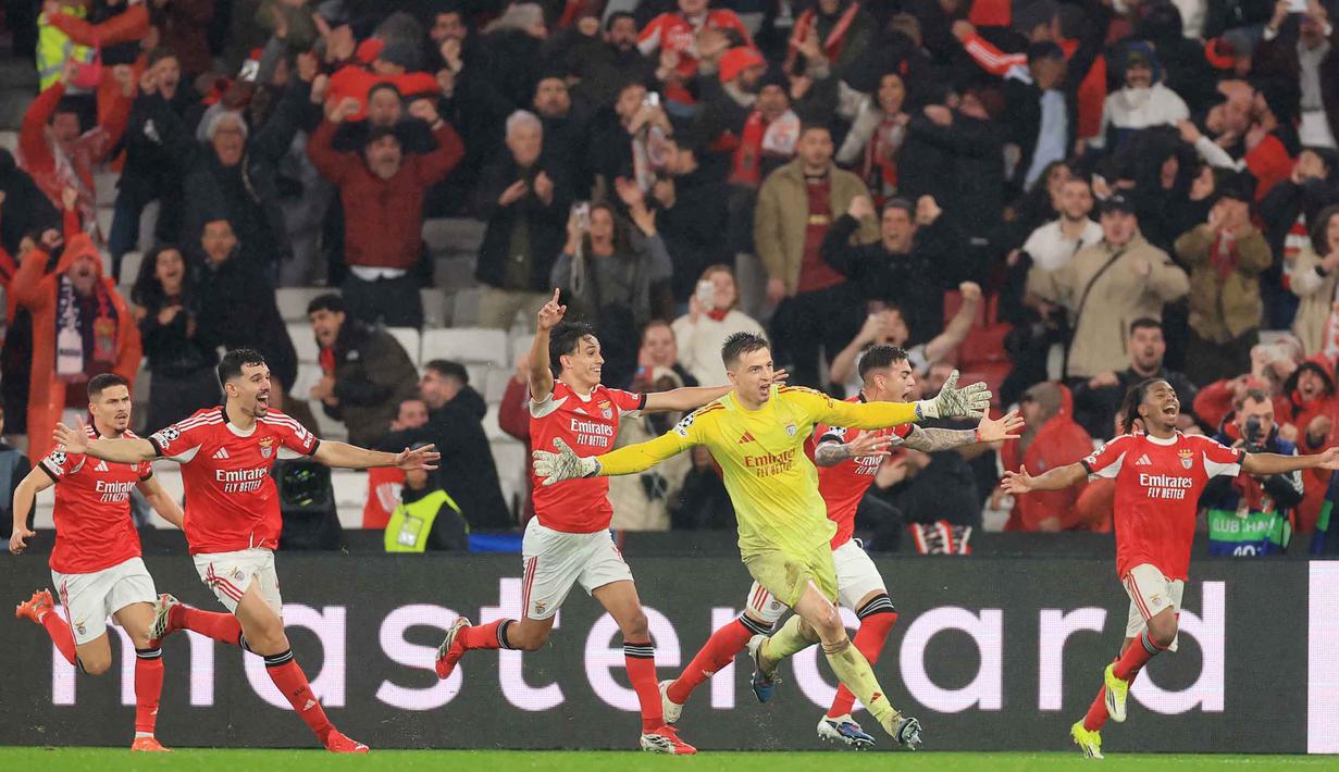 Anatoliy Trubin menyebut dirinya sempat kebingungan sebelum akhirnya maju ke kotak penalti lawan. Tampak dalam foto, kiper Benfica asal Ukraina, Anatoliy Trubin (C) merayakan gol keempat timnya selama pertandingan pekan ke-8 Liga Champions 2025-2026 melawan Real Madrid di Estadio da Luz, Lisbon, Rabu (28/1/2026) waktu setempat atau Kamis (29/1/2026) dini hari WIB. (PATRICIA DE MELO MOREIRA/AFP)