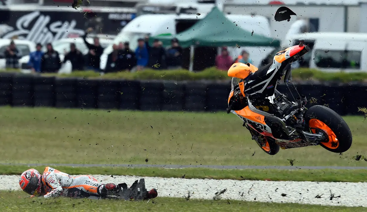 Pembalap Spanyol, Marc Marquez terjatuh saat balapan MotoGP Australia di Sirkuit Philip Island, Australia (21/10). Marc Marquez terjatuh di lap sembilan dan tidak bisa melanjutkan lomba. (AFP/Jerey Brown)