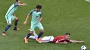 Pemain Portugal berusaha menghentikan pergerakan pemain Hungaria, Adam Szalai, pada laga Grup F Piala Eropa 2016 di Stade de Lyon, Lyon, Rabu (22/6/2016). (AFP/Jean-Philippe Ksiazek)