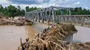 Diketahui, ada beberapa jembatan yang melintasi Sungai Peusangan di Kabupaten Bireuen, Aceh, dan dilaporkan putus atau rusak akibat banjir bandang pada akhir November 2025 lalu. Tampak foto udara menunjukkan warga memanjat puing-puing untuk menyeberangi sungai di jembatan yang baru dibangun yang menghubungkan Aceh dan Provinsi Sumatera Utara setelah hancur akibat banjir bandang di Sungai Peusangan di Distrik Bireuen, Provinsi Aceh, pada Selasa 9 Desember 2025. (CHAIDEER MAHYUDDIN/AFP)