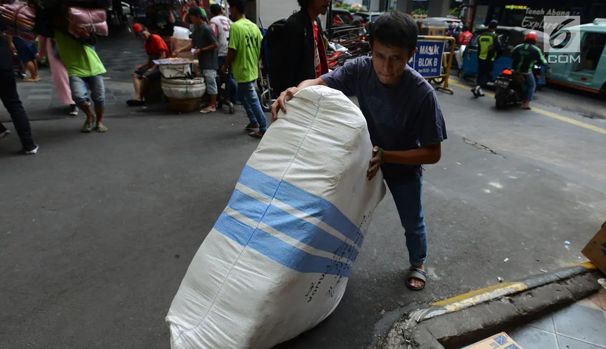 Pekerja membawa barang dagangan di Pasar Tanah Abang, Jakarta, Sabtu (25/5/2019). Pasca Aksi 22 Mei 2019, para pedagang mengalami kerugian karena perputaran uang di Tanah Abang mencapai Rp 200 miliar per hari. (merdeka.com/Imam Buhori)