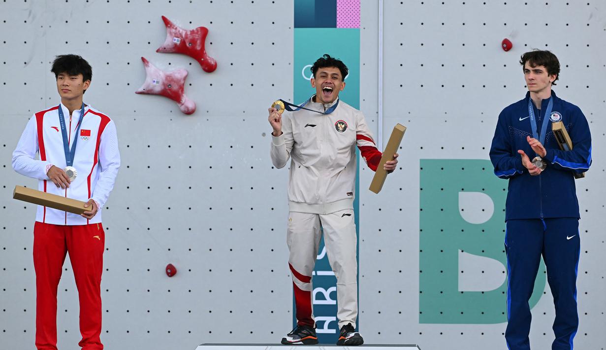 Atlet panjat tebing Indonesia, Veddriq Leonardo (tengah) melakukan selebrasi saat mendapatkan medali emas cabang olahraga pajat tebing nomor speed Olimpiade Paris 2024 di Le Bourget Sport Climbing Venue, Paris, Prancis, Kamis (08/08/2024). (AFP/Fabrice Coffriri)