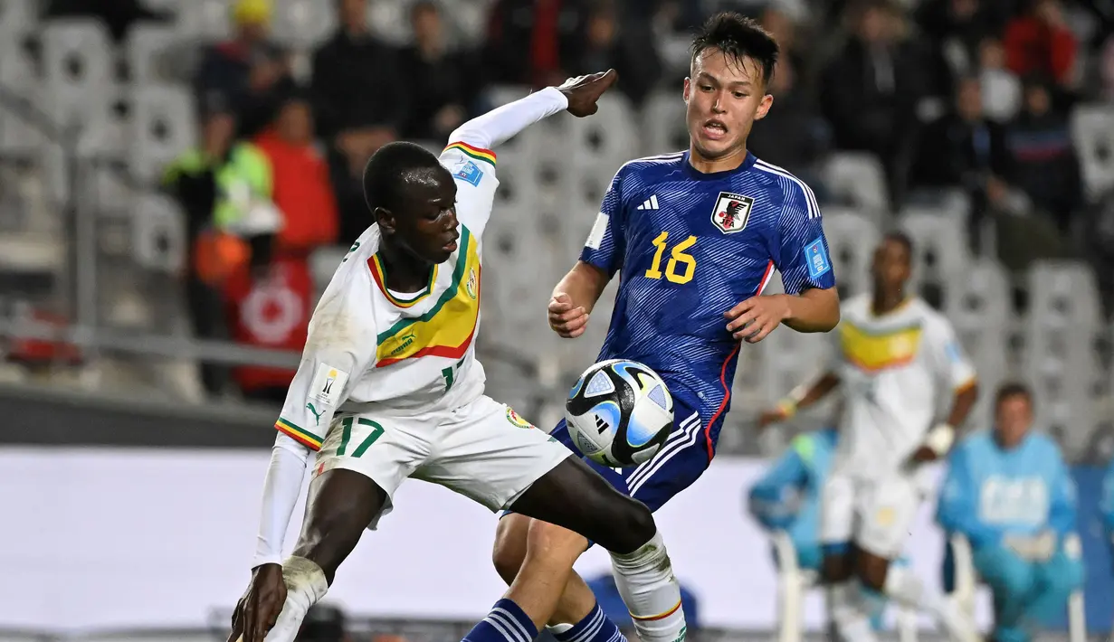 Pemain Timnas Jepang U-20, Niko Takahashi (kanan) berebut bola dengan pemain Senegal, Mame Mor Faye pada laga pertama Grup C Piala Dunia U-20 2023 di Estadio Unico Diego Armando Maradona stadium in La Plata, Argentina, on May 21, 2023. (AFP/Luis Robayo)