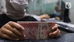 Teller menunjukkan uang rupiah di money changer, Jakarta, Rabu (9/9/2020). US$ 1 dibanderol Rp 14.780/US$ di pasar spot. Rupiah melemah 0,14% dibandingkan dengan penutupan perdagangan kemarin. (Liputan6.com/Angga Yuniar)