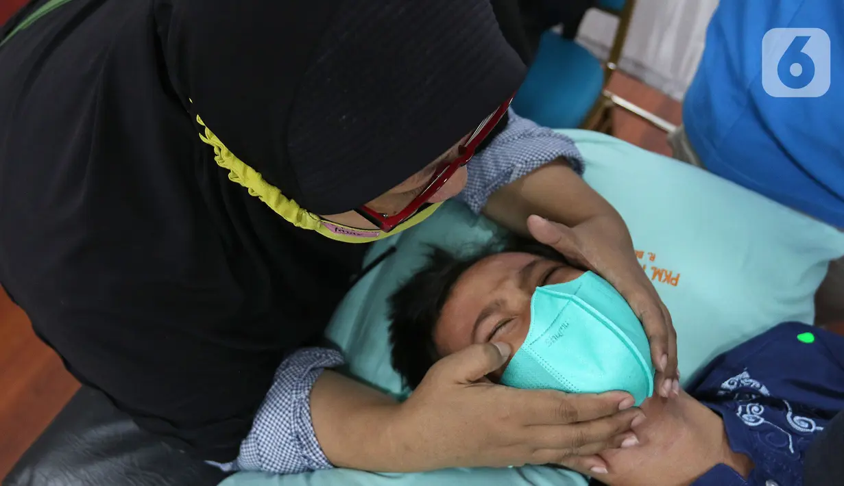 Seorang ibu berusaha menenangkan anaknya saat disunat di Puskesmas Kecamatan Cilandak, Jakarta, Kamis (2/12/2021). Sebanyak 50 anak mengikuti kegiatan sunat massal secara gratis dalam rangka Hari Kesehatan Nasional ke-57 mulai Selasa (30/11) hingga Juma (3/12). (Liputan6.com/Herman Zakharia)