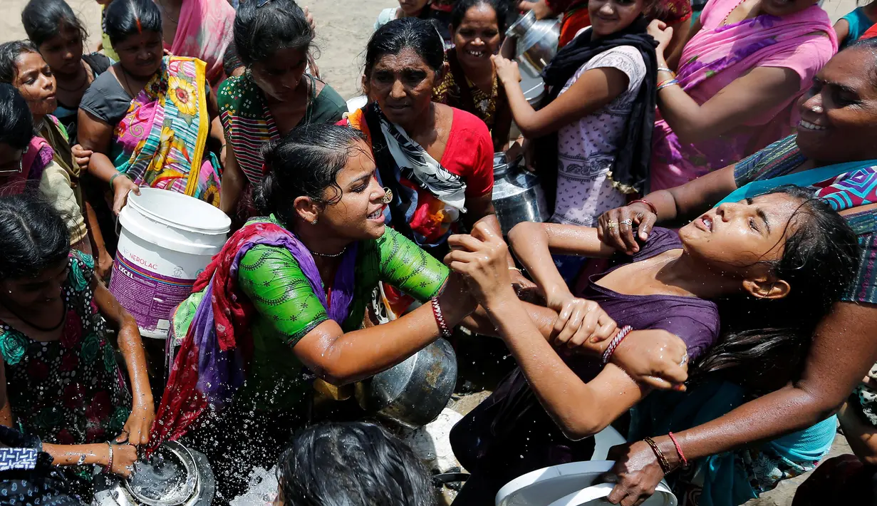 Warga saat berebut mengisi air kedalam ember mereka di pinggiran Ahmedabad , India 1 Juni 2016. Akibat gelombang panas ini, banyak sumur dan danau mengering yang mengakibatkan langkanya air di India. (REUTERS / Himanshu Sharma)