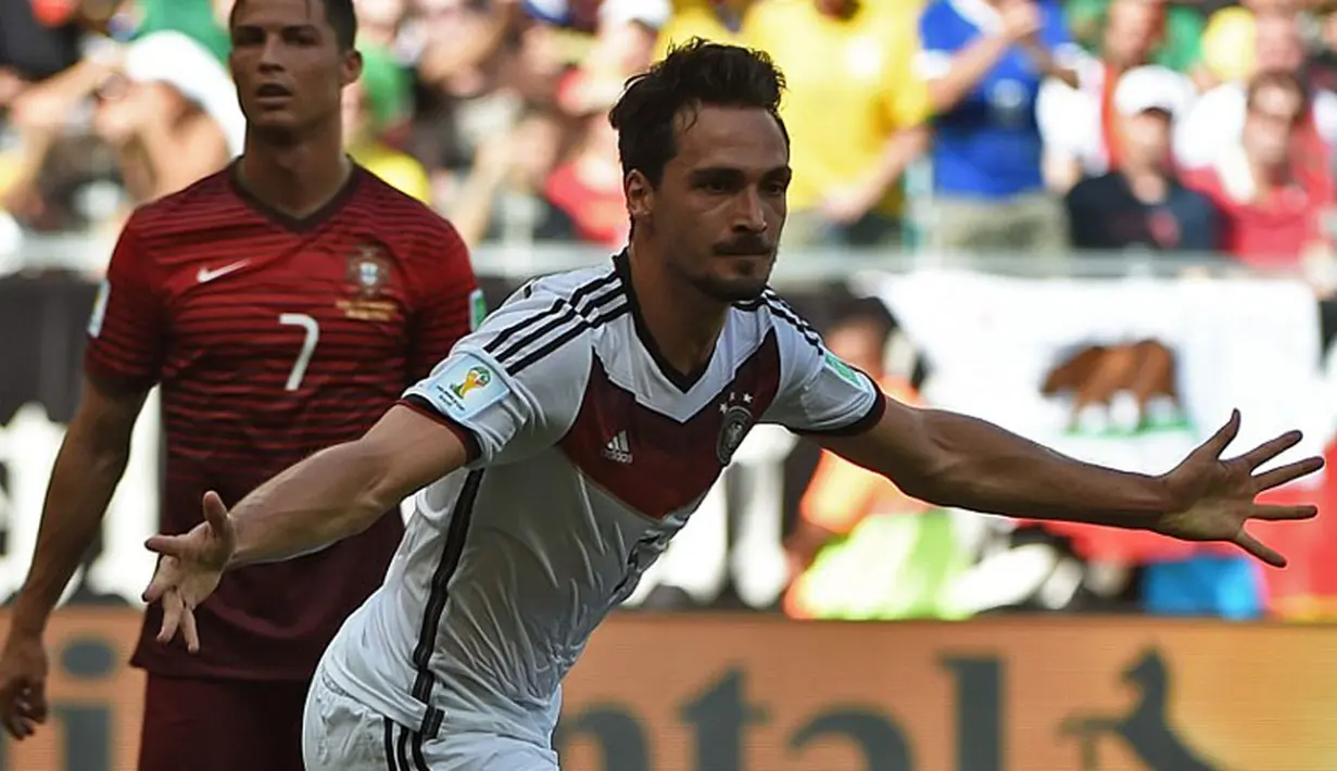Kapten Timnas Portugal, Cristiano Ronaldo (belakang) terpaku menyaksikan selebrasi Mats Hummels usai mencetak gol kedua buat Jerman di babak penyisihan Piala Dunia 2014 Grup G di Fonte Nova Arena, Brasil, (16/6/2014). (AFP PHOTO/Patrik Stollarz)