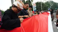 Warga Bandung menggelar aksi menjahit bendera merah putih di Jalan Perintis Kemerdekaan sebagai bagian peringatan Hari Kebangkitan Nasional. (Huyogo Simbolon)