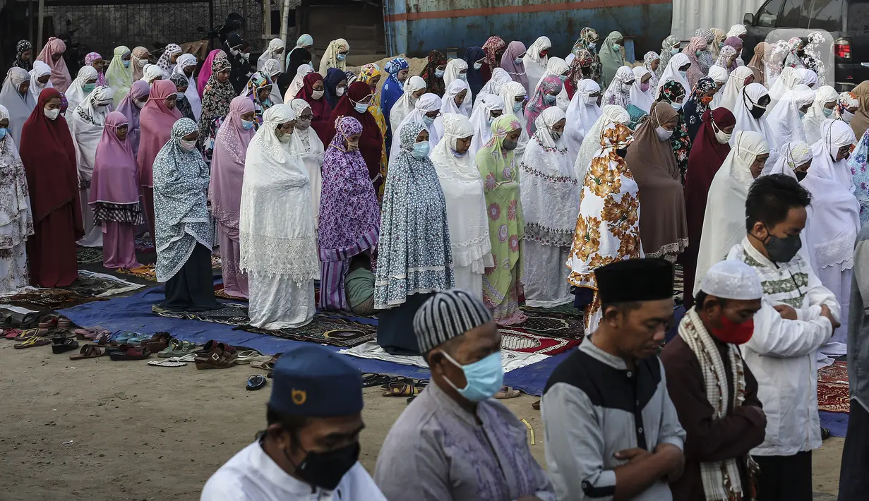 Umat muslim melaksanakan salat Idul Adha 1442 H berjemaah di Kali Baru, Cilincing, Jakarta, Selasa (20/7/2021). Salat tetap dilaksanakan saat pemberlakuan pembatasan kegiatan masyarakat (PPKM) Darurat untuk mencegah penularan COVID-19. (Liputan6.com/Johan Tallo)