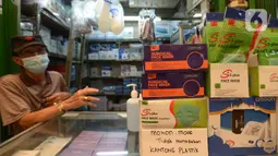 Pedagang menunggu pembeli masker tiga lapis di Pasar Pramuka, Jakarta, Rabu (23/9/2020). Terkait pelarangan pemakaian masker scuba dan buff di KRL, penjualan masker biasa masih normal di pasaran dengan harga sekitar Rp.60.000-Rp 150.000 per boks. (merdeka.com/Imam Buhori)
