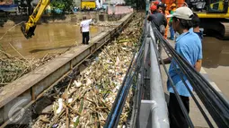 Warga melihat proses pengangkatan sampah dari jembatan Kampung Melayu, Jakarta, Minggu (3/4/2016). Akibat luapan Ciliwung, tumpukan sampah menyangkut di jembatan Kampung Melayu. (Liputan6.com/Yoppy Renato)