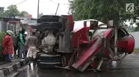 Pemandangan ketika sebuah truk molen terguling di Jalan Raya Lenteng Agung Barat, Jakarta, Kamis (26/4). Kecelakaan menyebabkan truk dan dua mobil penumpang mengalami kerusakan. (Liputan6.con/Immanuel Antonius)