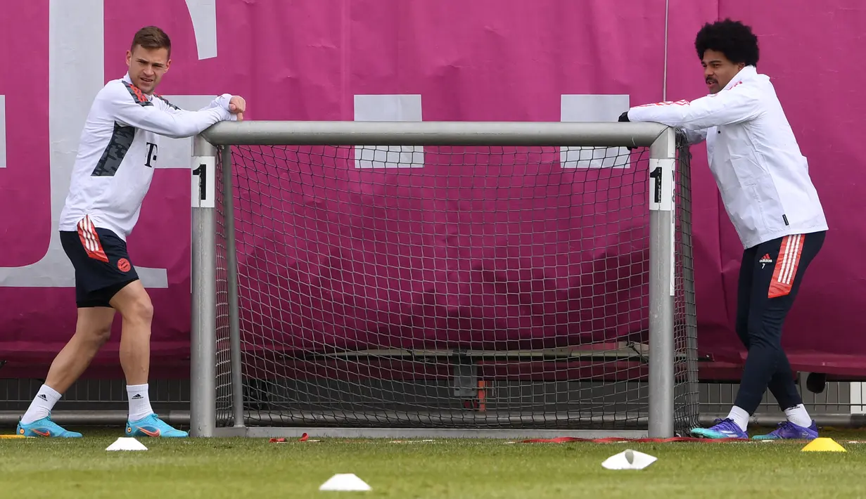 Gelandang Bayern Munchen Joshua Kimmich (kiri) dan Serge Gnabry melakukan peregangan selama sesi latihan di Munich, Senin (7/3/2022). Bayern Munchen akan menjalani laga leg kedua melawan RB Salzburg di Allianz Arena pada Rabu (9/3) dini hari WIB. (Christof STACHE / AFP)