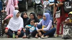 Warga duduk di jalan jelang kirab atau arak-arakan acara resepsi Kahiyang Ayu Siregar-Bobby Nasution di Kota Medan, Sumatera Utara Minggu (26/11). (Liputan6.com/Johan Tallo)