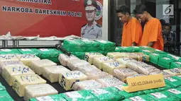 Tersangka dan barang bukti diperlihatkan saat rilis di Jakarta, Kamis (21/12). Bareskrim Polri menahan tiga tersangka dan menyita 100 kilogram narkotika jenis sabu di Belawan, Medan pada (12/12) lalu. (Liputan6.com/Herman Zakharia)