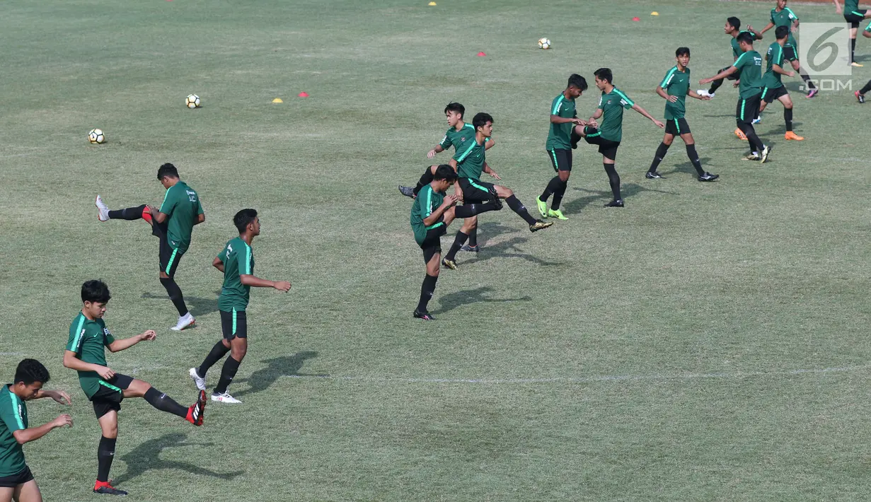 Pemain Timnas Indonesia U-19 melakukan pemanasan saat latihan di Lapangan B Kompleks GBK, Jakarta, Selasa (18/9). Latihan ini persiapan  PSSI Anniversary Cup U-19 dan Piala AFC U19. (Liputan6.com/Helmi Fithriansyah)
