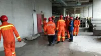 Petugas berusaha mengevakuasi korban tangga darurat roboh (Liputan6.com/ Fernando Purba)