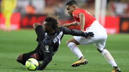 Pemain Nice, Allan Saint-Maximin (kiri) jatuh saat melewati adangan pemain Monaco, Jorge (kanan) pada lanjutan Ligue 1 di Louis II Stadium, Monaco, (16/1/2018). AS Monaco bermain imbang 2-2 dengan Nice. (AFP/Valery Hache)