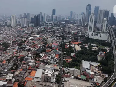 Foto dari ketinggian memperlihatkan kondisi pemukiman padat penduduk berlatar gedung bertingkat di Jakarta, Jumat (23/2/2024). (Liputan6.com/Angga Yuniar)