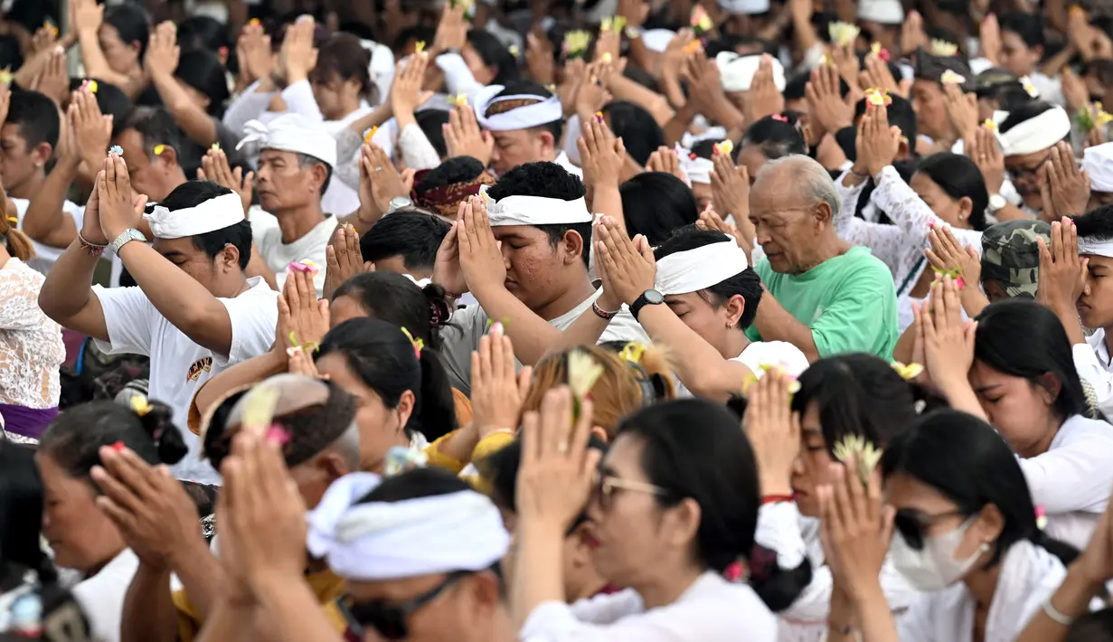 Umat Hindu Bali berdoa selama upacara Banyu Pinaruh di desa Mertasari, Sanur, pada 7 September 2025. (SONNY TUMBELAKA/AFP)