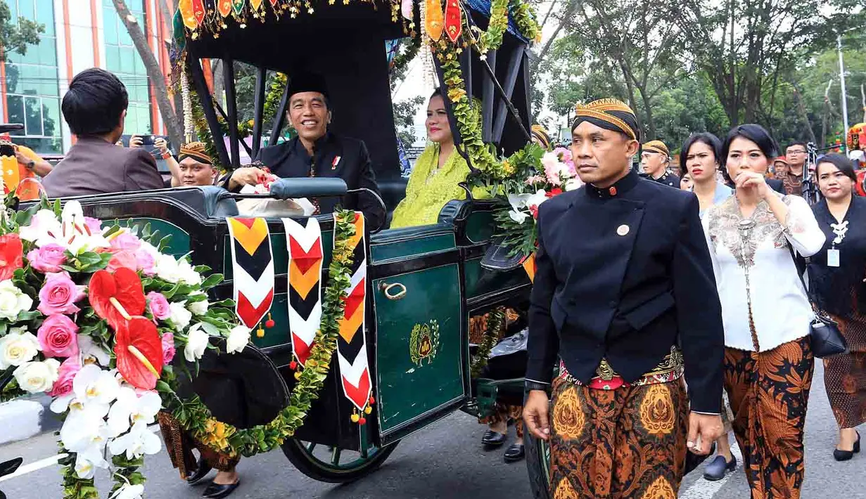 Kedua pengantin yang tengah berbahagia juga menyapa warga yang antusias menanti iring-iringan di sepanjang jalan yang menjadi rute kirab budaya. Senyum ceria menyapa warga. (Deki Prayoga/Bintang.com)
