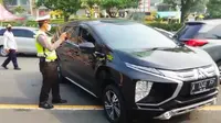 Polisi menempel stiker khusus untuk kendaraan plat Surabaya dan Gresik saat larangan mudik. (Dian Kurniawan/Liputan6.com)