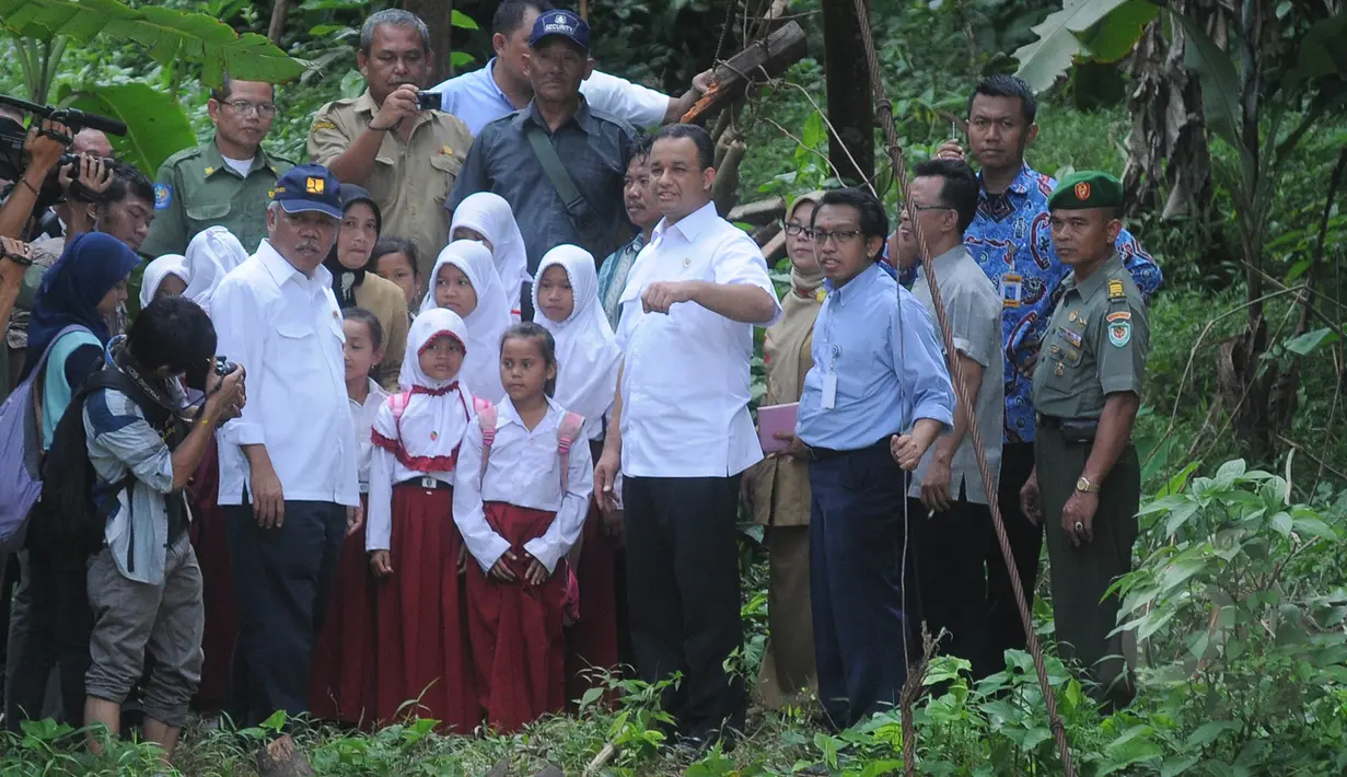 Mendikbud Anies Baswedan bersama rombongan saat meninjau jembatan yang roboh di Lebak, Banten, Senin (16/3/2015). Anies memerintahkan petugas untuk mengatarkan sejumlah siswa dengan perahu karet. (Liputan6.com/Herman Zakharia)