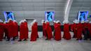 Pengunjuk rasa yang mendukung hak-hak perempuan berpakaian seperti karakter dari serial TV "The Handmaid's Tale" saat melakukan perjalanan untuk memprotes rencana pemerintah baru Perdana Menteri Benjamin Netanyahu untuk merombak sistem peradilan di sebuah stasiun kereta api di Yerusalem, Israel, 1 Maret 2023. Mengacu pada fenomena yang berkembang, harian Inggris The Guardian menggambarkan penampilan para pelayan sebagai salah satu simbol paling kuat dari protes feminis kontemporer. (AP Photo/Ohad Zwigenberg)