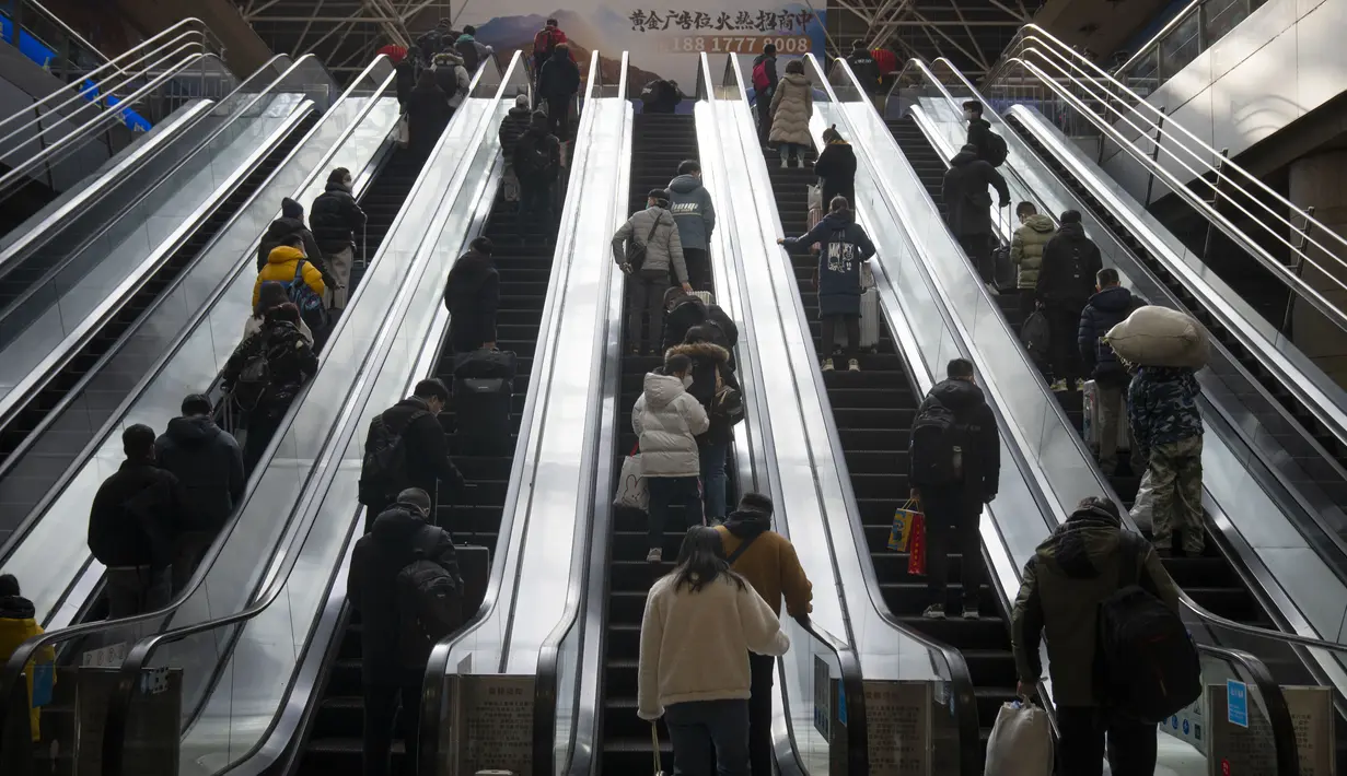Para pelancong menaiki eskalator di Stasiun Kereta Api Beijing Barat di Beijing, Rabu, 18 Januari 2023. China pada Desember mencabut kebijakan "nol-COVID" yang ketat, melepaskan gelombang keinginan perjalanan yang terpendam, terutama di sekitar waktu terpenting China untuk pertemuan keluarga, yang disebut di China sebagai Festival Musim Semi, yang mungkin satu-satunya waktu di satu tahun ketika pekerja perkotaan kembali ke kampung halaman mereka. (AP Photo/Mark Schiefelbein)