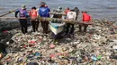 Nelayan beraktivitas di pantai Sukaraja yang tercemar sampah plastik di Bandar Lampung pada 8 September 2019. Selain berserakan dan aroma tak sedap, sampah-sampah di pesisir tersebut juga menyebabkan banyaknya ikan yang mati. (Photo by PERDIANSYAH / AFP)