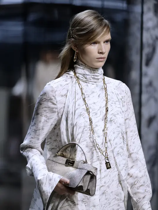 Ada detail kristal putih yang menghiasi bentuk khas dari FENDI O'Lock, sedangkan varian khusus hadir dengan gembok yang hanya bisa dibuka dengan menekan FENDI, seperti pada anting-anting kunci atau kalung rantai kunci. Foto: Document/FENDI.