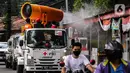 Petugas Palang Merah Indonesia (PMI) menyemprotkan disinfektan menggunakan armada Gunner Spray di kawasan Blok M, Jakarta, Minggu (12/4/2020). PMI mengerahkan 10 unit Gunner Spray berkapasitas 5.000 liter yang didesain khusus untuk menyemprotkan disinfektan secara masif. (Liputan6.com/Faizal Fanani)