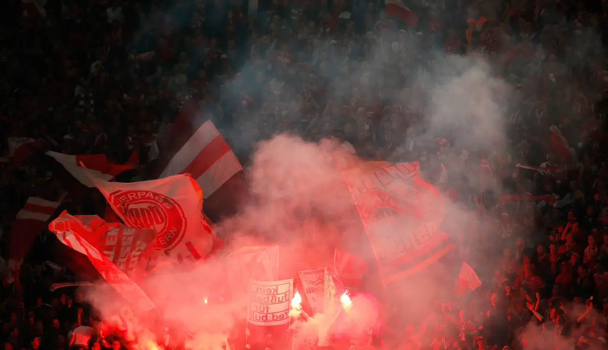 Suporter Bayern Munchen menyalakan flare saat merayakan gelar juara DFB Pokal setelah mengalahkan RB Leipzig di Stadion Olympic, Berlin, Sabtu (25/5). Munchen menang 3-0 atas Leipzig. (AFP/Odd Andersen)