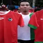 Penjual Jersey timnas tunjukkan barang yang dijual (Liputan6.com/Antonius Hermanto)