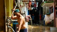 Warga mengambil air bersih saat banjir melanda pemukiman Kampung Pulo, Jakarta, Rabu (25/11/2015). Air aliran kali Ciliwung mulai memasuki rumah warga sekitar pukul 03.00 Wib dini hari tadi. (Liputan6.com/Yoppy Renato)