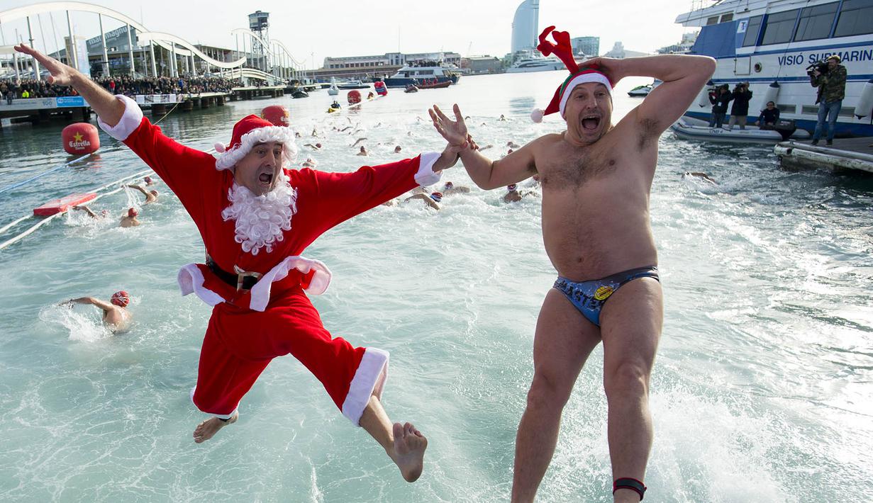 Seorang peserta dengan menggunakan kostum Sinterklas megikuti lomba renang Copa Nadal di Port Vell, Barcelona, Minggu (25/12/2016). omba tradisional ini sudah diadakan sebanyak 107 kali. (AFP/Josep Lago)