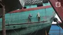 Pekerja menyelesaikan perbaikan kapal nelayan di Galangan Kapal Muara Angke, Jakarta Utara, Kamis (23/5/2024). (merdeka.com/Imam Buhori)